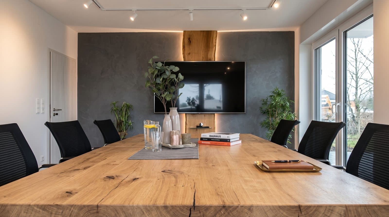 Besprechungstisch aus Massivholz nach Maß mit Bildschirm an der Wand