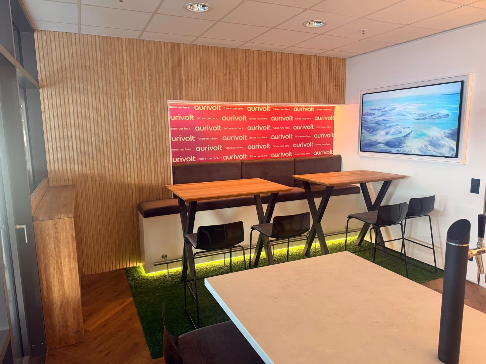 Gepolsterte Sitzbank mit zwei Hochtischen in der Lounge-Ecke einer Stadionloge