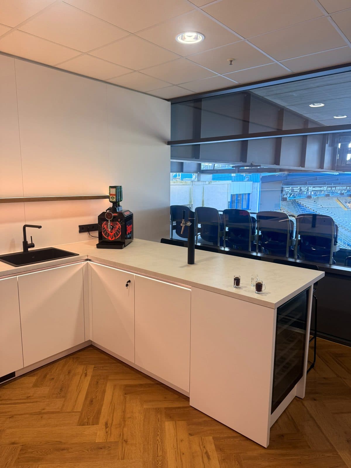 Weißer Tresen mit Zapfsäule in einer Loge von Arminia Bielefeld, dahinter Logenplätze und Tribüne